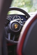Interior of a vehicle with steering wheel and rear instruments, Porsche Taycan, Deer Carsharing,
