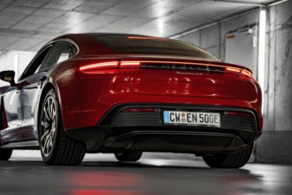 Red car in an underground garage, modern lighting, sporty rear, Porsche Taycan, Deer Carsharing,