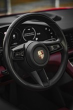 Black steering wheel in the luxurious interior of a Porsche, Porsche Taycan, Deer Carsharing. Calw,