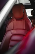 Red leather seat in the luxurious interior of a car, Porsche Taycan, Deer car sharing. Calw,