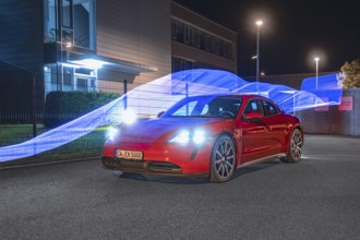 Red car at night with light strips in the background, Porsche Taycan, deer car sharing. Calw,