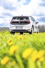 A white car is parked in a meadow, photographed from the rear view, ID3 VW, Deer Carsharing. Calw,