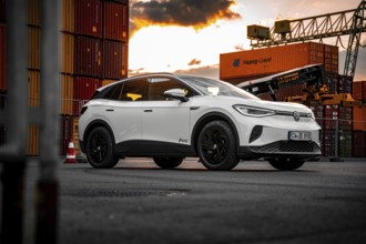 Silver car at sunset surrounded by containers, VW ID4 electric car, Deer Carsharing, Calw, Germany