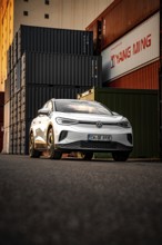 Silver car in front of high-stacked containers, VW ID4 electric car, Deer Carsharing, Calw, Germany