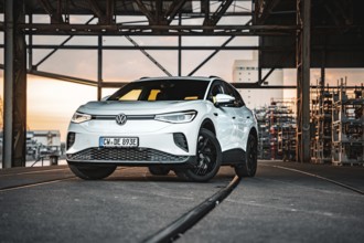 A car stands on rails in an industrial area at sunset, VW ID4 electric car, Deer Carsharing, Calw,