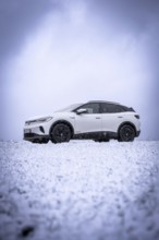 White car on snowy field under cloudy sky, VW ID4 electric car, Deer Carsharing, Calw, Germany
