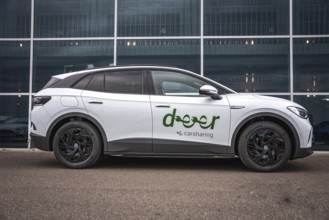 Side view of white car in front of modern offices, VW ID4 electric car, Deer Carsharing, Calw,