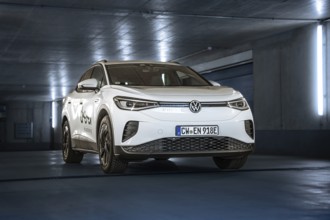 White car in a modern, illuminated underground car park with urban flair, VW ID4 electric car, Deer