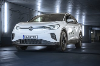White Volkswagen in parking garage with LED lights and urban flair, VW ID4 electric car, Deer