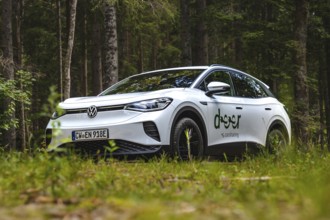 White Volkswagen in the forest from a low perspective, VW ID4 electric car, Deer Carsharing, Calw,