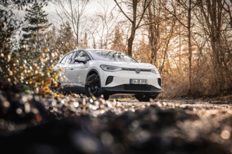 Car in an autumn forest landscape with bare trees, VW ID4 electric car, Deer Carsharing, Calw,