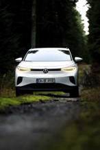 Front view of a car on a dark forest road, VW ID4 electric car, Deer Carsharing, Calw, Germany