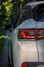 Back view of a car in the woods on a small path, VW ID4 electric car, Deer Carsharing, Calw,