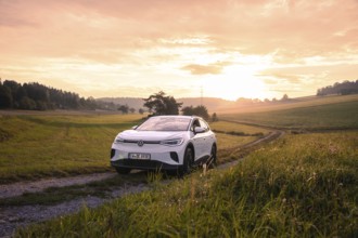 A car on a dirt road at sunset in a rural setting, VW ID4 electric car, Deer Carsharing, Calw,
