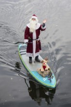 A water sports enthusiast dressed up as Santa Claus rides a SUP on the Spree in Berlin on 30.11
