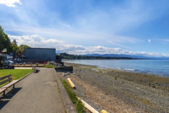Calm ocean waters lapping a pebbled shore at qualicum beach on vancouver island, british columbia,