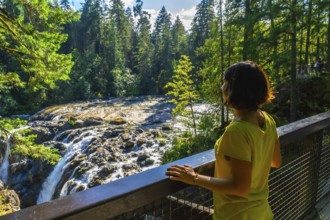 Tourist wearing a yellow t shirt is enjoying the view of englishman river falls from a viewpoint on