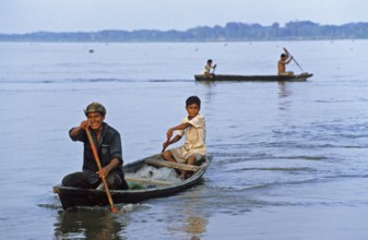 Father and son in a paddle boat on the Amazon near Iquitos, Peru, South America, September 1997,