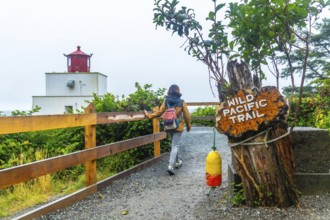 Female tourist walking along the gravel path of the wild pacific trail near amphitrite point