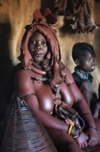 Himba woman sitting with baby, Himba perfume, scented smoke from burning plants, Himba village,