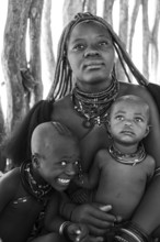 Black and white, Himba woman with baby and grinning child, traditional Himba village, Kaokoveld,
