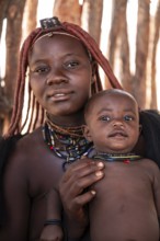 Himba woman with baby, traditional Himba village, Kaokoveld, Kunene, Namibia