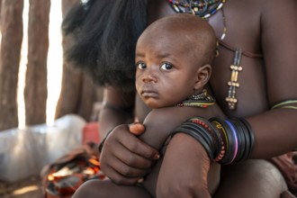 Himba woman with baby, traditional Himba village, Kaokoveld, Kunene, Namibia