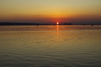 Sunset over a calm lake, orange sky, peaceful atmosphere, Steinhude Steinhuder Meer