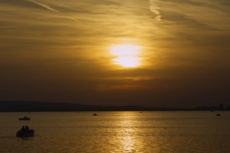 Several boats sail at atmospheric sunset on the lake, Steinhude, Steinhuder Meer