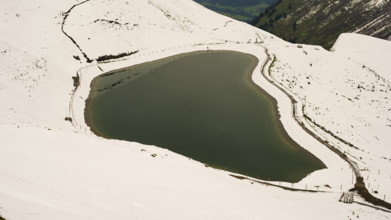 Another onset of winter in May, Riezler Alpsee, an artificially created lake, snow pond, feeds the