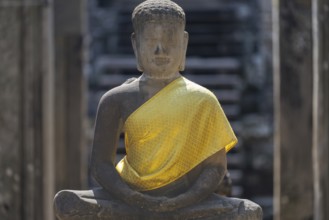 Sandstone Buddha statue, (Dhyana-mudra: gesture of meditation), with yellow tunic, on the north