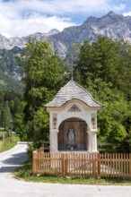 Small trail chapel with the Slovenian Alps in the background, mountaineering village Zgornje
