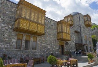 A building with decorative wooden windows, stone walls and cozy terrace furniture, Rabati Fortress,