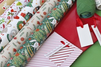 Close up of Christmas wrapping material like paper, bags and ribbons on green background