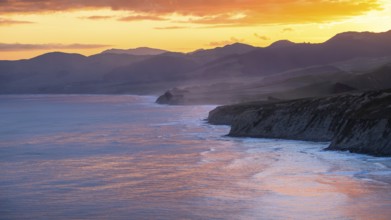 Wairarapa coast at sunset. Sea, mountains, backlight. Castlepoint, Wairarapa Coast, Wellington
