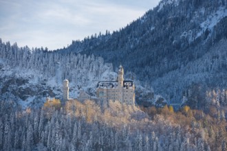 Neuschwanstein Castle in the winter panorama, surrounded by snow-covered forests and mountains,