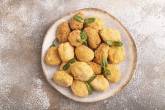 Fried crispy Chicken Nuggets with ketchup, microgreen on brown concrete background. top view, flat