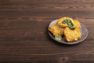 Fried crispy Chicken pancakes on brown wooden background. side view, copy space