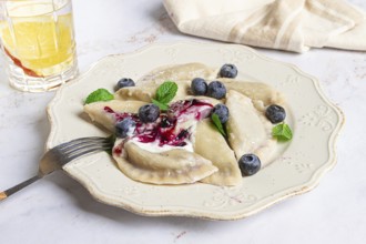 Handmade dumplings filled with sweet ingredients, arranged beautifully on a white plate, topped