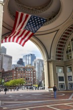 American flag fluttering, distinctive archway, Boston Harbor Hotel, Rowes Wharf, passers-by,