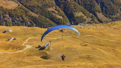 A paraglider takes off from the summit of Corne de Sorebois, Val d'Anniviers, Valais Alps, Canton