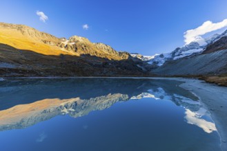 The Moiry glacier and mountain peaks are reflected in Lac de Chateaupre, Val d'Anniviers, Valais