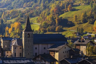 The church of Sainte-Euphemie in Vissoie, in the back a mountain landscape in autumn colors, Val