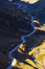 The mountain road from Grimentz to the Lac de Moiry reservoir with autumn colors, Val d'Anniviers,