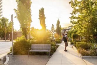 Father enjoying quality time with his baby while strolling through a vibrant vancouver park,