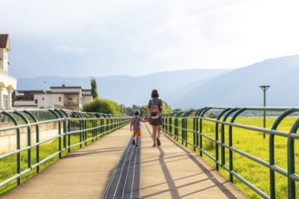 Mother and son enjoying a leisurely stroll on a pedestrian bridge in salmon arm, british columbia,