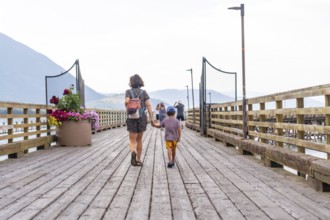 Mother and son enjoying a leisurely stroll along a picturesque wooden pier in salmon arm, british