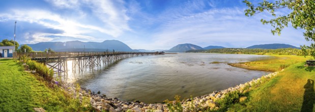 Panoramic view of a long wooden pier stretching into the tranquil waters of shuswap lake,