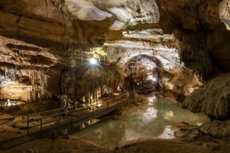 Stalactites and stalagmites, small underground lake with reflection, rock formations in a
