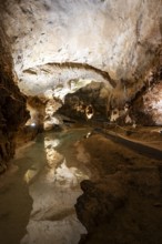 Stalactites and stalagmites, small underground lake, rock formations in a stalactite cave, Grotta